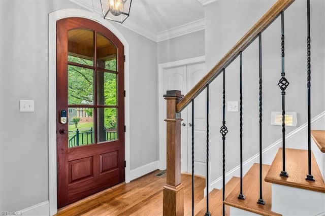 6 Yardarm Ct, Greensboro, NC 27455 - foyer entrance featuring arched walkways, ornamental molding, wood finished floors, stairs, and baseboards