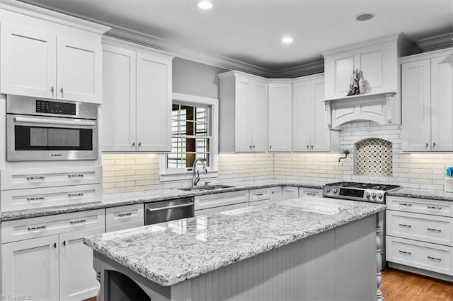 6 Yardarm Ct, Greensboro, NC 27455 - kitchen featuring stainless steel appliances, a sink, white cabinetry, a center island, and tasteful backsplash