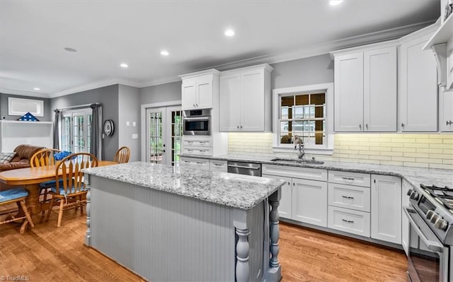 6 Yardarm Ct, Greensboro, NC 27455 - kitchen featuring a sink, appliances with stainless steel finishes, crown molding, white cabinets, and a center island