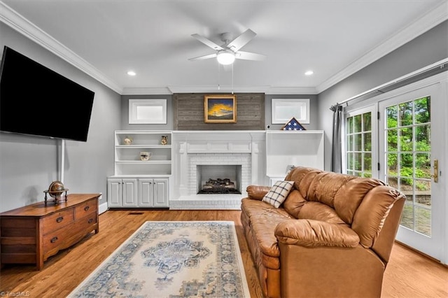 6 Yardarm Ct, Greensboro, NC 27455 - living room featuring crown molding, a ceiling fan, light wood-style flooring, a brick fireplace, and recessed lighting