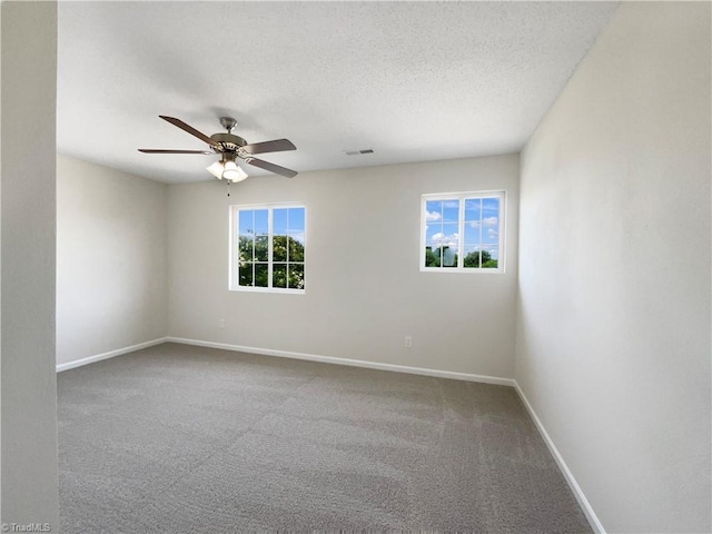 carpeted spare room featuring a textured ceiling and ceiling fan