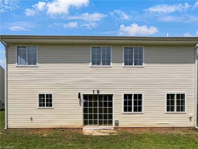 rear view of house featuring a yard