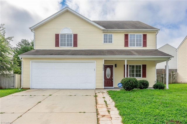 traditional-style home featuring concrete driveway, a front lawn, an attached garage, and fence