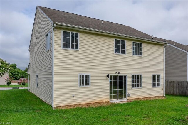 rear view of property featuring a yard