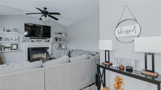 living room featuring a fireplace, ceiling fan, and lofted ceiling