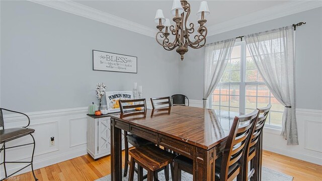 dining room featuring light hardwood / wood-style floors, an inviting chandelier, a wealth of natural light, and crown molding