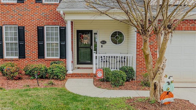 doorway to property with covered porch and a garage