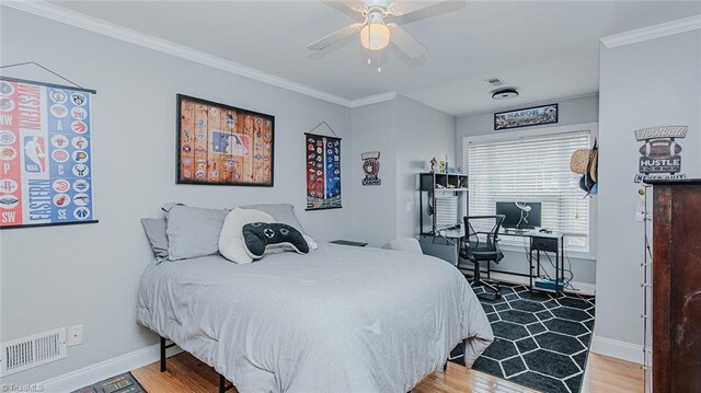 bedroom with hardwood / wood-style floors, ceiling fan, and crown molding