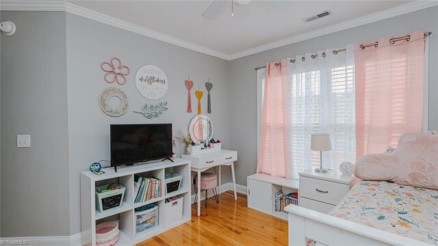 bedroom featuring ceiling fan, wood-type flooring, and crown molding