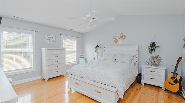 bedroom with ceiling fan, light hardwood / wood-style floors, and vaulted ceiling