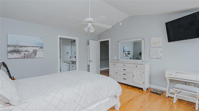 bedroom featuring connected bathroom, ceiling fan, light hardwood / wood-style floors, and vaulted ceiling