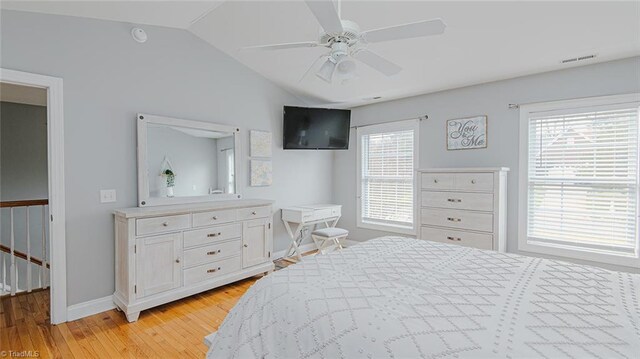 bedroom featuring ceiling fan, light hardwood / wood-style floors, and lofted ceiling