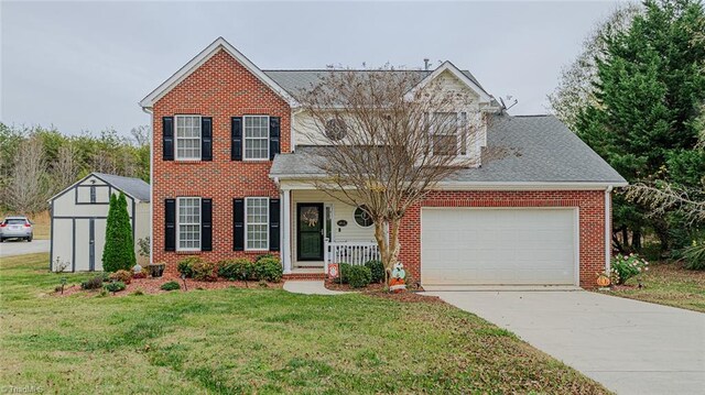 view of front of property featuring a front lawn, covered porch, and a garage