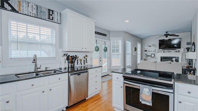 kitchen featuring appliances with stainless steel finishes, french doors, sink, light hardwood / wood-style flooring, and white cabinetry