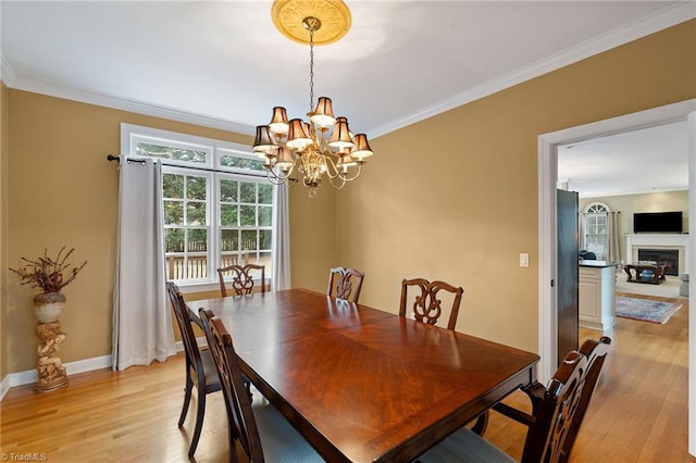 dining space featuring light hardwood / wood-style flooring, crown molding, and a chandelier