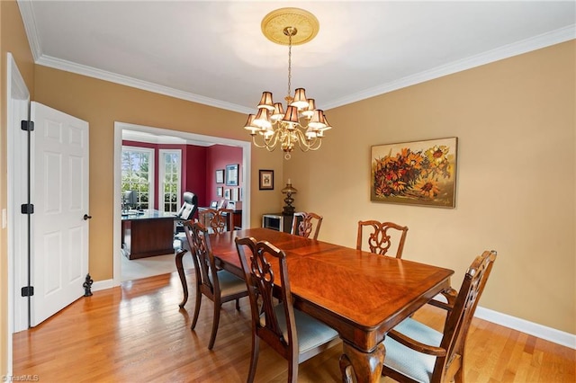 dining area with light hardwood / wood-style flooring, ornamental molding, and an inviting chandelier