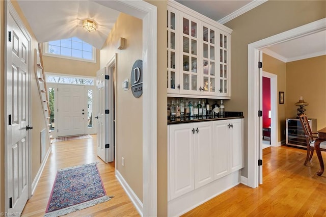 hallway with light hardwood / wood-style floors and ornamental molding