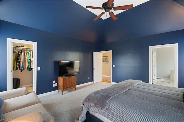 bedroom featuring a spacious closet, light carpet, a closet, vaulted ceiling, and ceiling fan