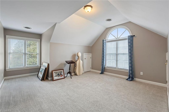 bonus room with light carpet, plenty of natural light, and lofted ceiling