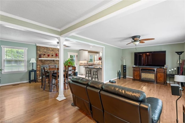 510 Hampton Dr, King, NC 27021 - living area with a ceiling fan, wood finished floors, a fireplace, crown molding, and a textured ceiling