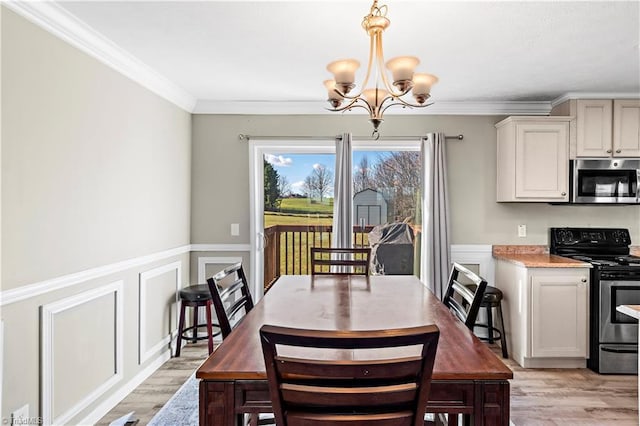 dining space featuring crown molding, light hardwood / wood-style flooring, and an inviting chandelier