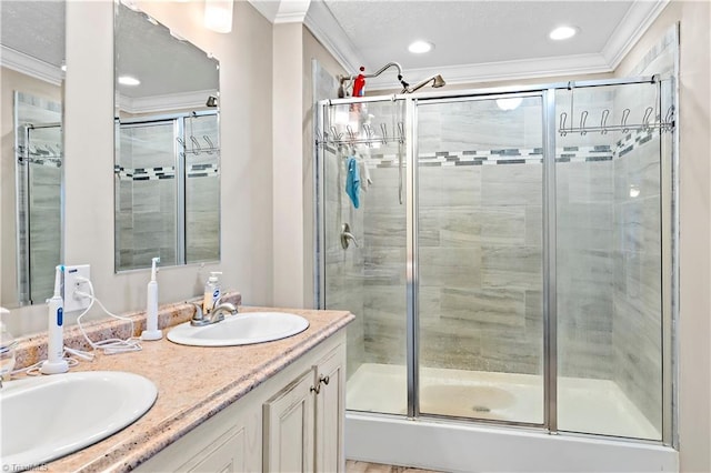 bathroom with a shower with shower door, ornamental molding, and vanity