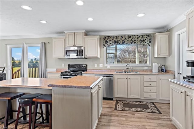 kitchen featuring sink, a center island, stainless steel appliances, and light wood-type flooring