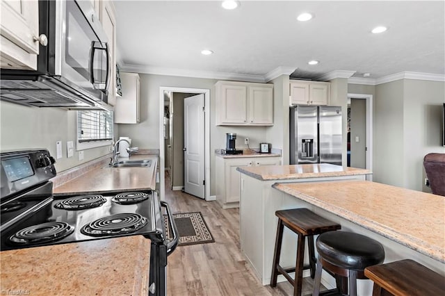 kitchen with sink, stainless steel appliances, light hardwood / wood-style floors, white cabinets, and ornamental molding