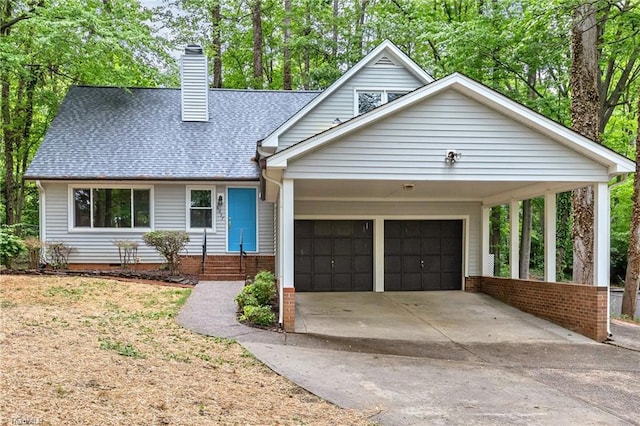 view of front of property featuring a garage, roof with shingles, a chimney, driveway, and a carport
