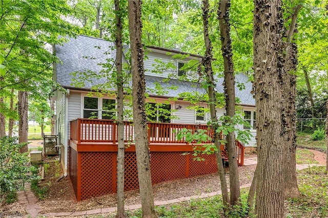 back of property featuring a shingled roof and a deck