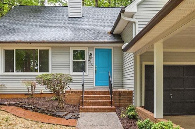 property entrance with roof with shingles, a chimney, and a garage