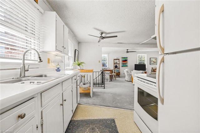 kitchen featuring white cabinetry, sink, white appliances, and a textured ceiling