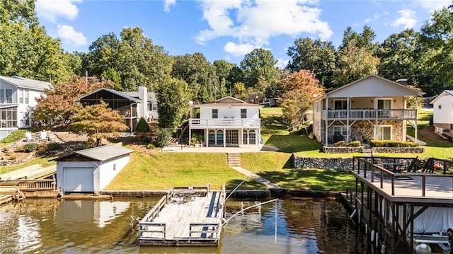 dock area featuring a deck with water view, a balcony, and a yard