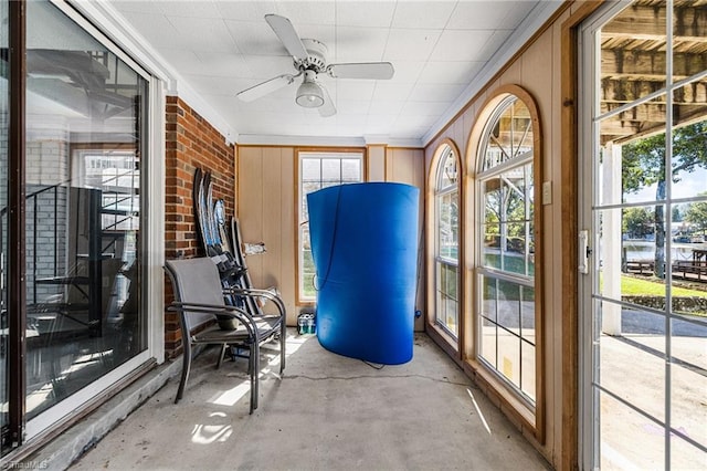 unfurnished sunroom with ceiling fan