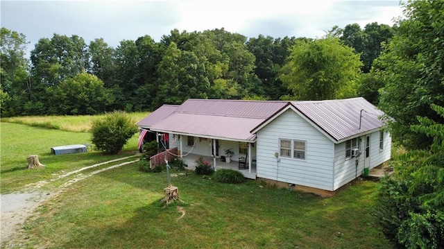 view of front of home with cooling unit, covered porch, and a front yard