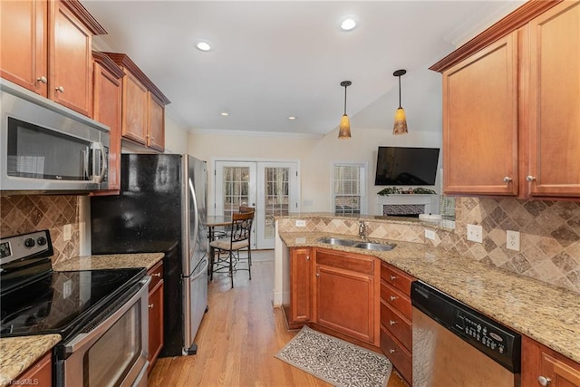 kitchen featuring sink, stainless steel appliances, light hardwood / wood-style flooring, decorative light fixtures, and decorative backsplash