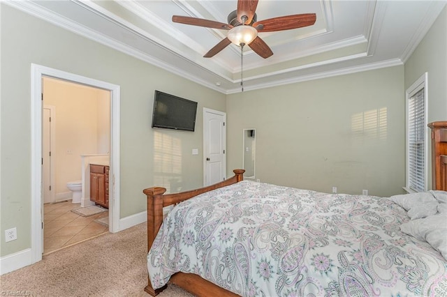 bedroom featuring connected bathroom, ceiling fan, crown molding, a tray ceiling, and light carpet