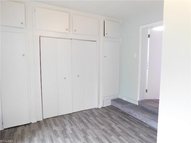 unfurnished bedroom featuring light hardwood / wood-style flooring and a closet