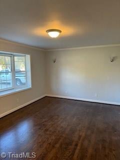 spare room featuring crown molding and dark hardwood / wood-style flooring