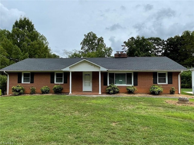 single story home with a front lawn, a chimney, and brick siding