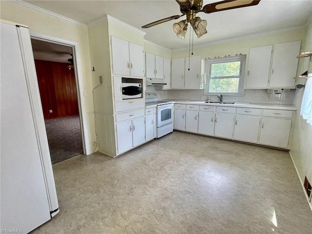 kitchen with white appliances, white cabinets, light countertops, crown molding, and under cabinet range hood