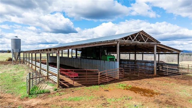 view of stable with an outbuilding and a rural view