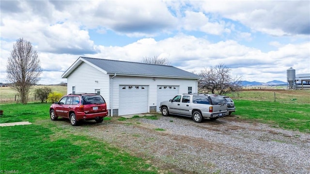 garage with a mountain view and a lawn