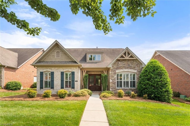 5584 Foxgate Cir, Winston-Salem, NC 27106 - craftsman house featuring french doors, a front yard, stone siding, and brick siding