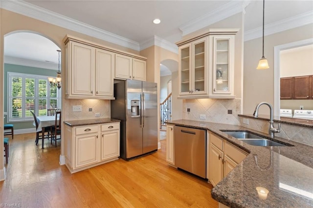 5584 Foxgate Cir, Winston-Salem, NC 27106 - kitchen with appliances with stainless steel finishes, arched walkways, a sink, cream cabinetry, and dark stone countertops