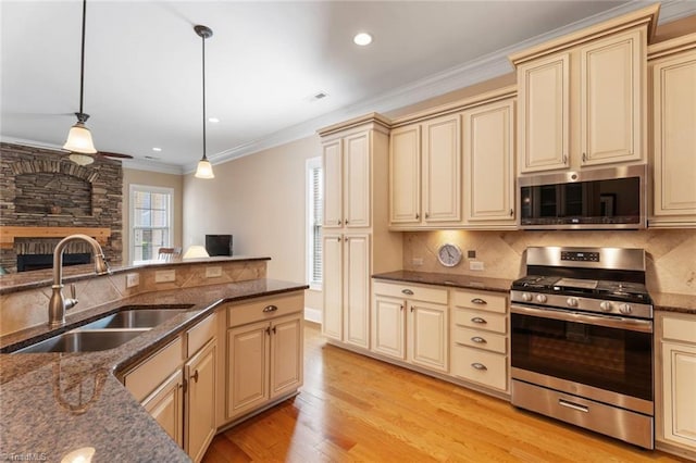 5584 Foxgate Cir, Winston-Salem, NC 27106 - kitchen with stainless steel appliances, cream cabinetry, a sink, tasteful backsplash, and light wood finished floors