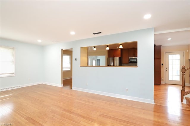 unfurnished living room featuring plenty of natural light, light wood-style flooring, and recessed lighting