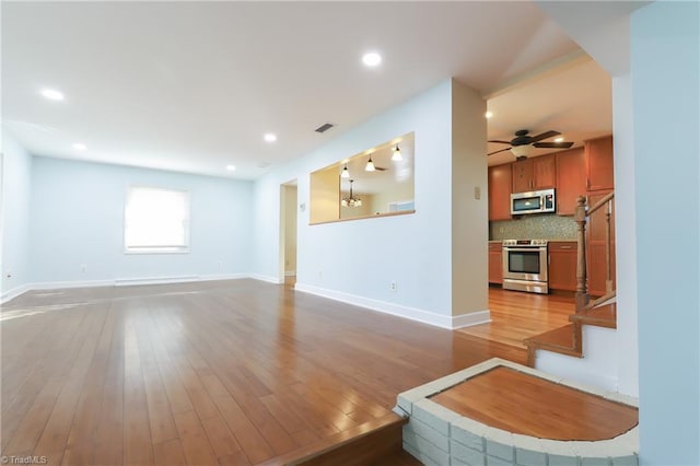 living area featuring baseboards, visible vents, wood finished floors, stairs, and recessed lighting