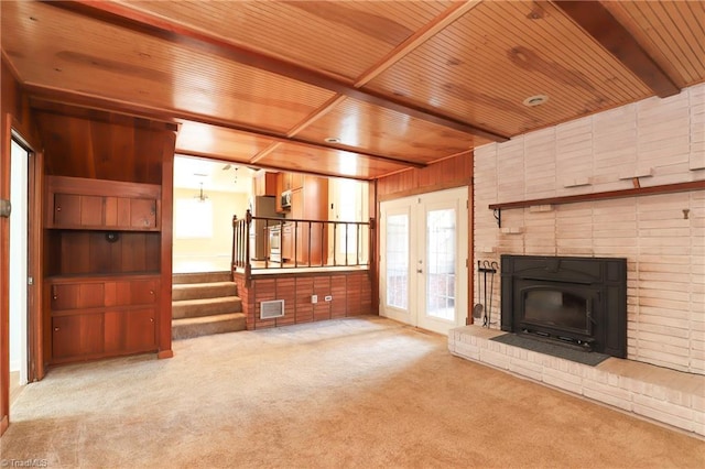 unfurnished living room featuring wooden ceiling, a fireplace, carpet flooring, stairway, and beam ceiling