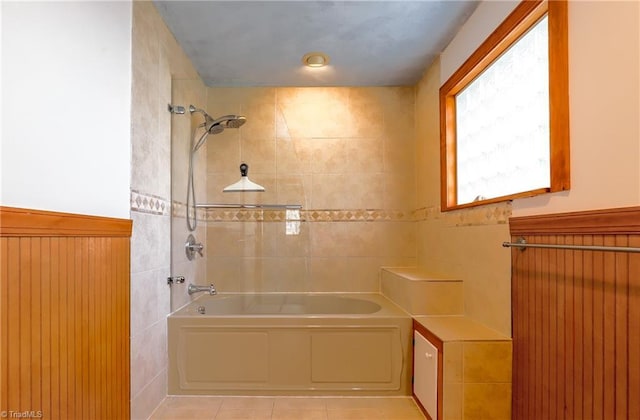 full bathroom with a wainscoted wall and tub / shower combination